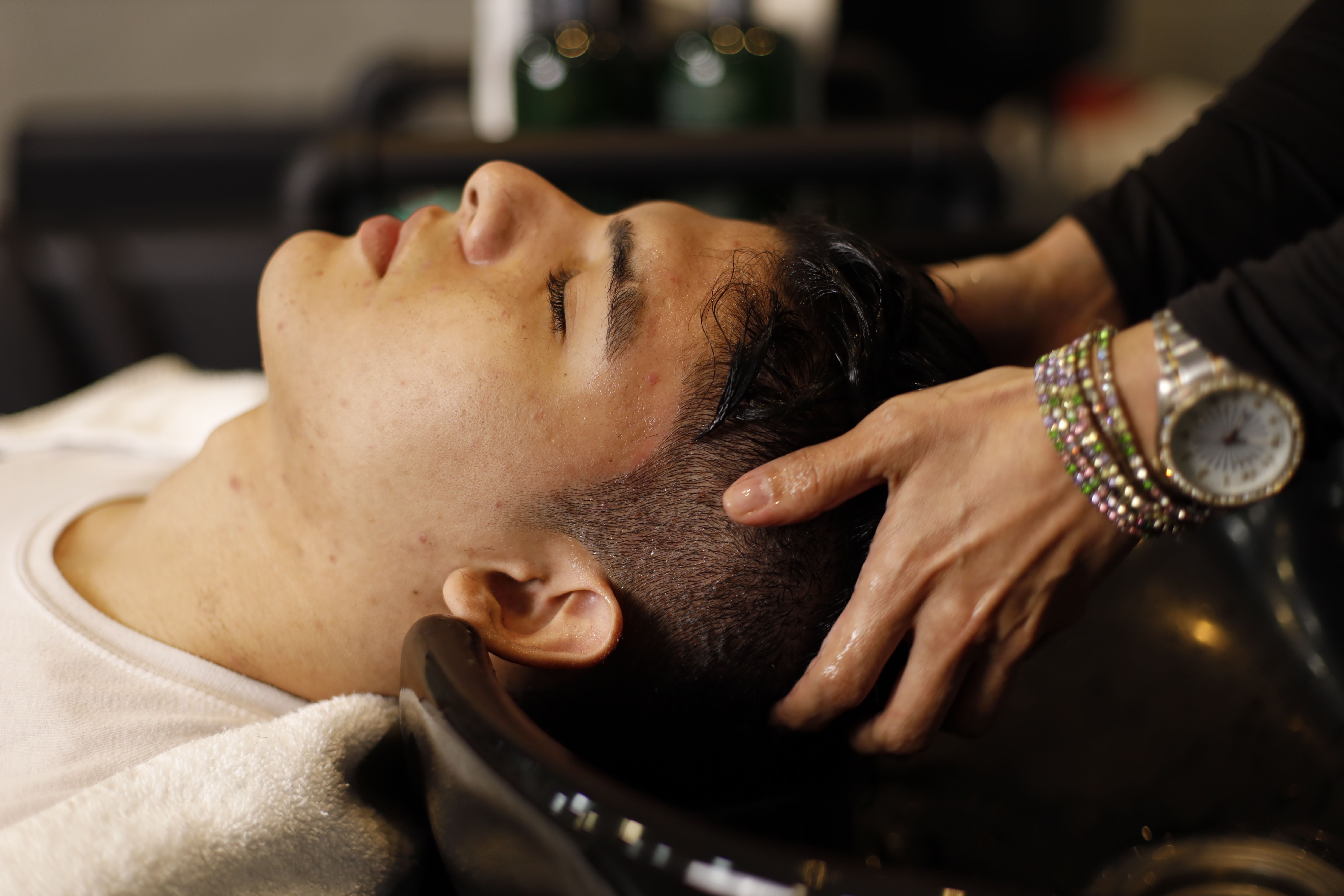 a person getting spa like treatment, hair wash and scalp massage