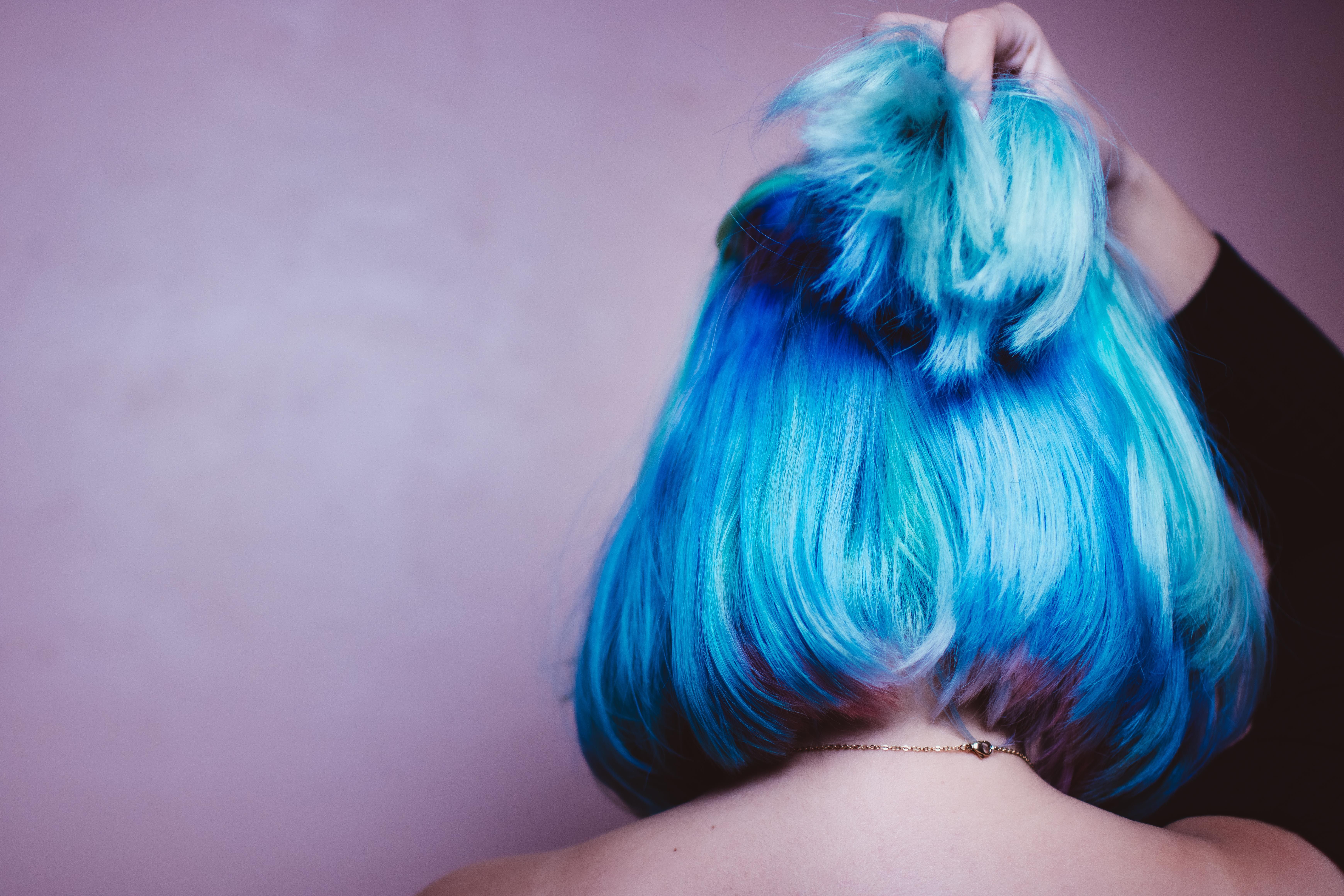 a lady getting her hair died blue